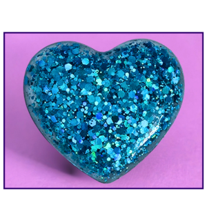 Blue glitter-covered heart on a pink background with a dark purple border, decorative image