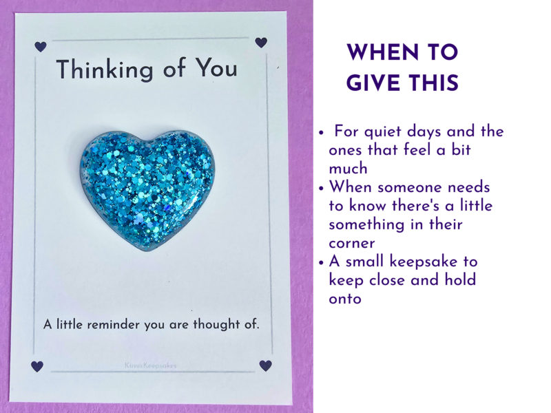 Card with white panel, blue glitter heart, and the words 'Thinking of You' on a purple-bordered background.