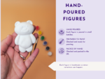 Close-up of a hand holding a white ceramic bear figurine against an orange background, with a lavender infographic panel on the right reading 'HAND-POURED FIGURES'.