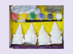 White ceramic figurines arranged with a paint set (red, yellow, green, blue, gray, white), glue, and brushes on a yellow craft tray
