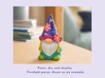 Colorful ceramic gnome wearing a purple party hat with pink flowers sits on a wooden table, with a blurred background.