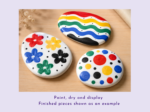 KNP-PYO-STONES-0033. Painted result Colorfully painted decorative stones with flower patterns and rainbow stripes on a wooden surface.
