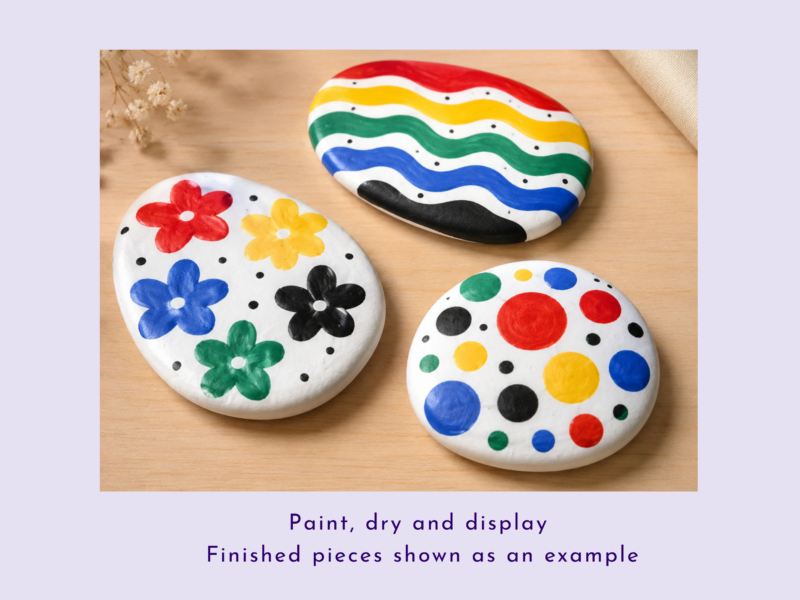 Colorfully painted decorative stones with flower patterns and rainbow stripes on a wooden surface.
