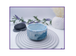 Small blue and white marbled decorative pot styled on a striped surface with neutral décor
