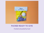 DIY paint-your-own kit in a yellow bag on an orange background, with a white model and painting supplies visible inside.