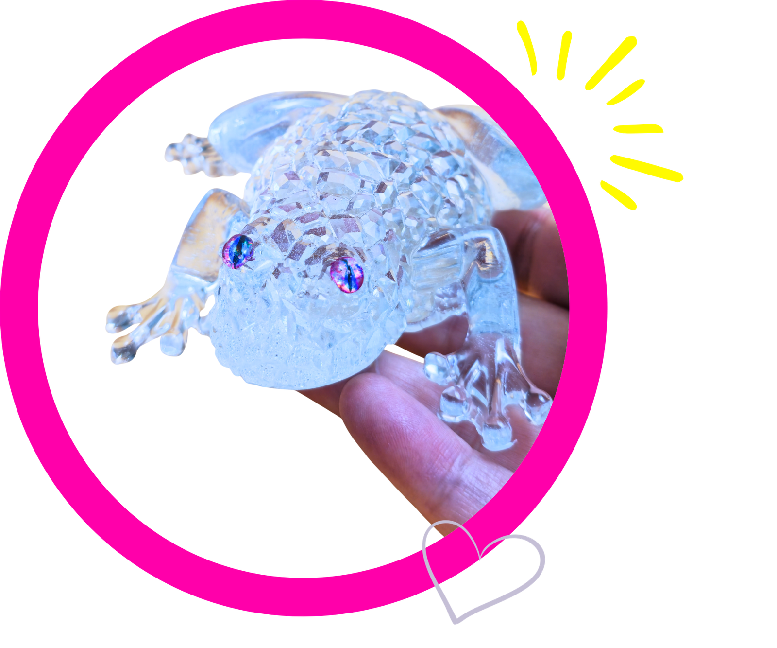 Clear crystal turtle figurine being held between fingers, showing a faceted surface and iridescent eyes with a bright pink circular frame in the background (decorative image).
