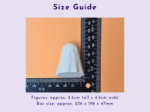 Close-up of a black metric ruler beside a small white plastic piece on an orange background, showing measurement markings.