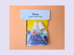 KNP-PYO-GHOST-mini03Hero photo Kirnic Paint Your Own art kit with paints and ceramic shapes in a clear bag on an orange background