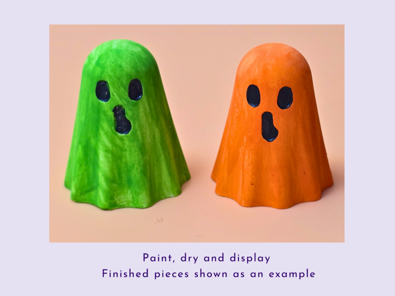 Two bright ghost-shaped gourds, one green and one orange, stand side by side on a pale surface as a craft display.