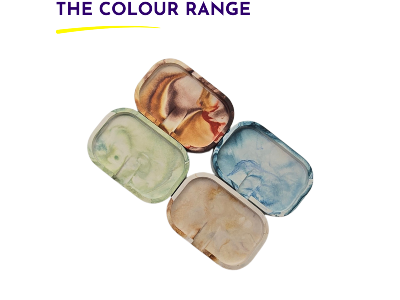 Watercolor paint pans arranged in a diagonal stack showing a spectrum of colors on a white background, conveying a color range image.