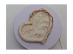 Clay brain model placed on a light purple plate against a gray background.