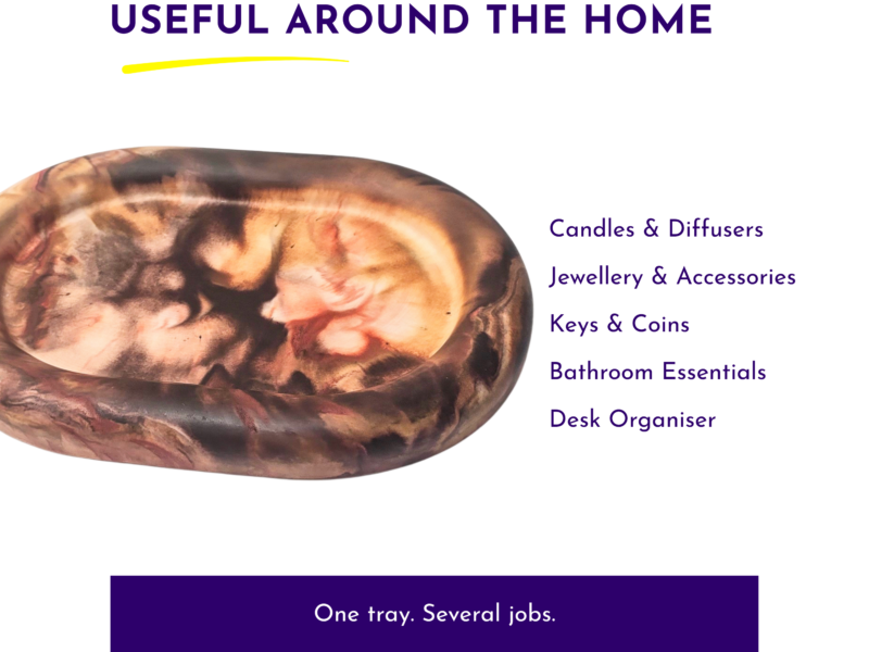 Left side shows a large marbled stone, with the heading 'Useful Around The Home' at top and a vertical list of categories on the right (Candles & Diffusers, Jewellery & Accessories, Keys & Coins, Bathroom Essentials, Desk Organiser), plus a dark purple banner at the bottom reading 'One tray. Several jobs'.