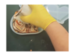 Gloved hand pressing a swirl of chocolate and vanilla batter inside a light bowl.