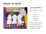 Contents of a paint kit: white ghost-shaped pieces, paint pots, brushes, glitter, and a plastic palette on purple tissue