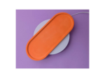 Orange protective case placed diagonally on a purple background, with a white circular pad nearby (product shot).