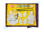 Open Brick Buddy paint-your-own craft kit showing five blank figures, six paint pots, two brushes, palette, glitter, glue and instructions.