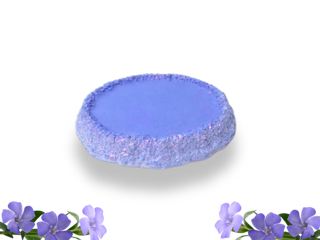 Round Periwinkle purple coaster with a smooth centre and raised druzy-effect edge featuring pink and violet shimmer. Purple flowers decorate the corners of the white background.