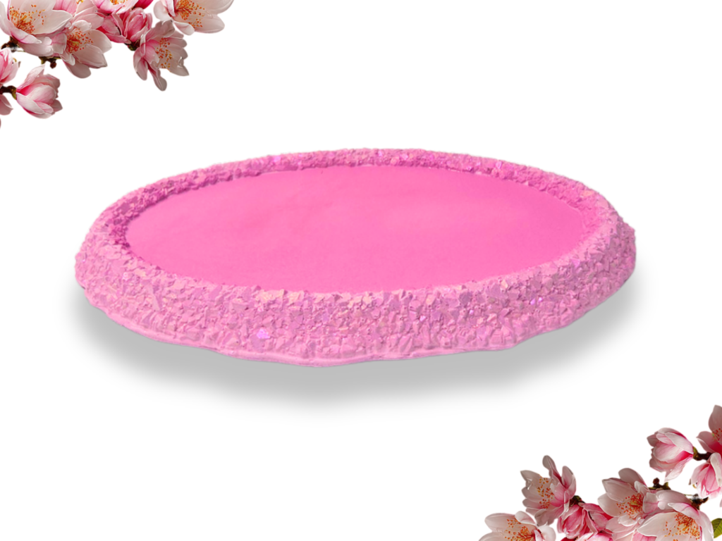 Handmade Mulberry pink oval trinket tray with a smooth centre and raised, crystal-effect edge featuring iridescent shimmer, photographed on white.